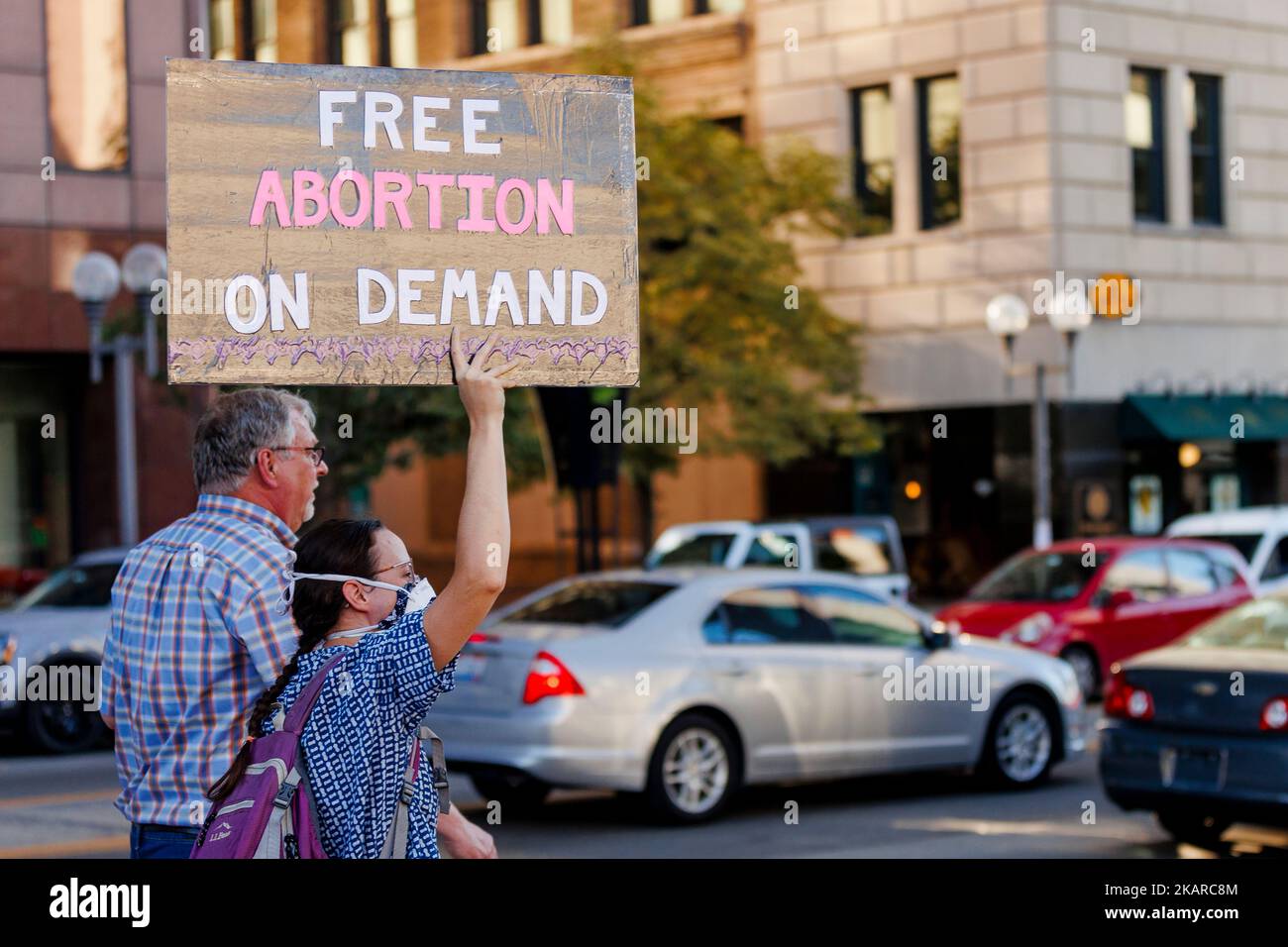 Abortion rights protesters stand by busy street holding a sign Stock Photo
