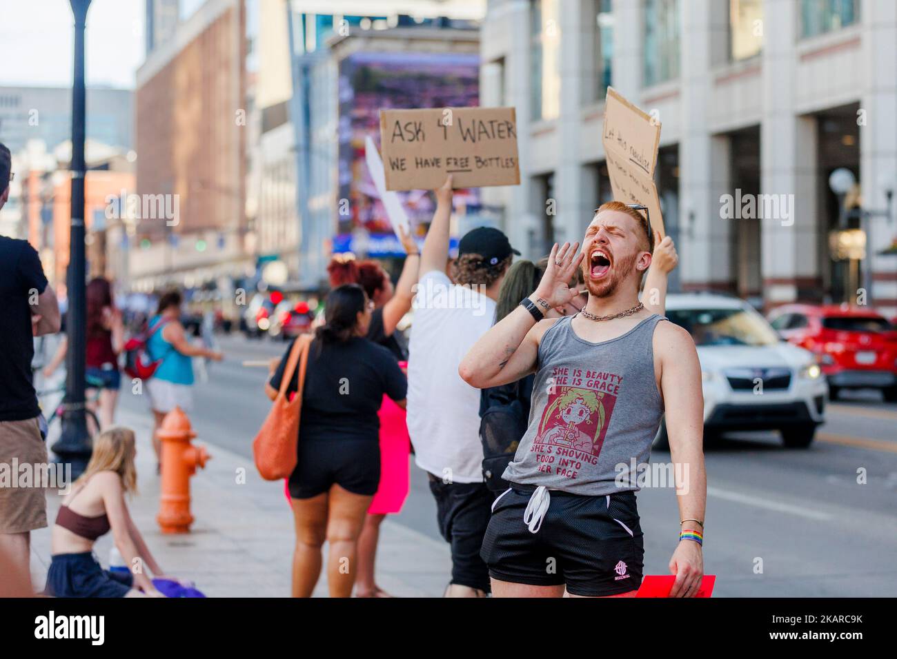 A man yelling loudly at a protest along city street Stock Photo