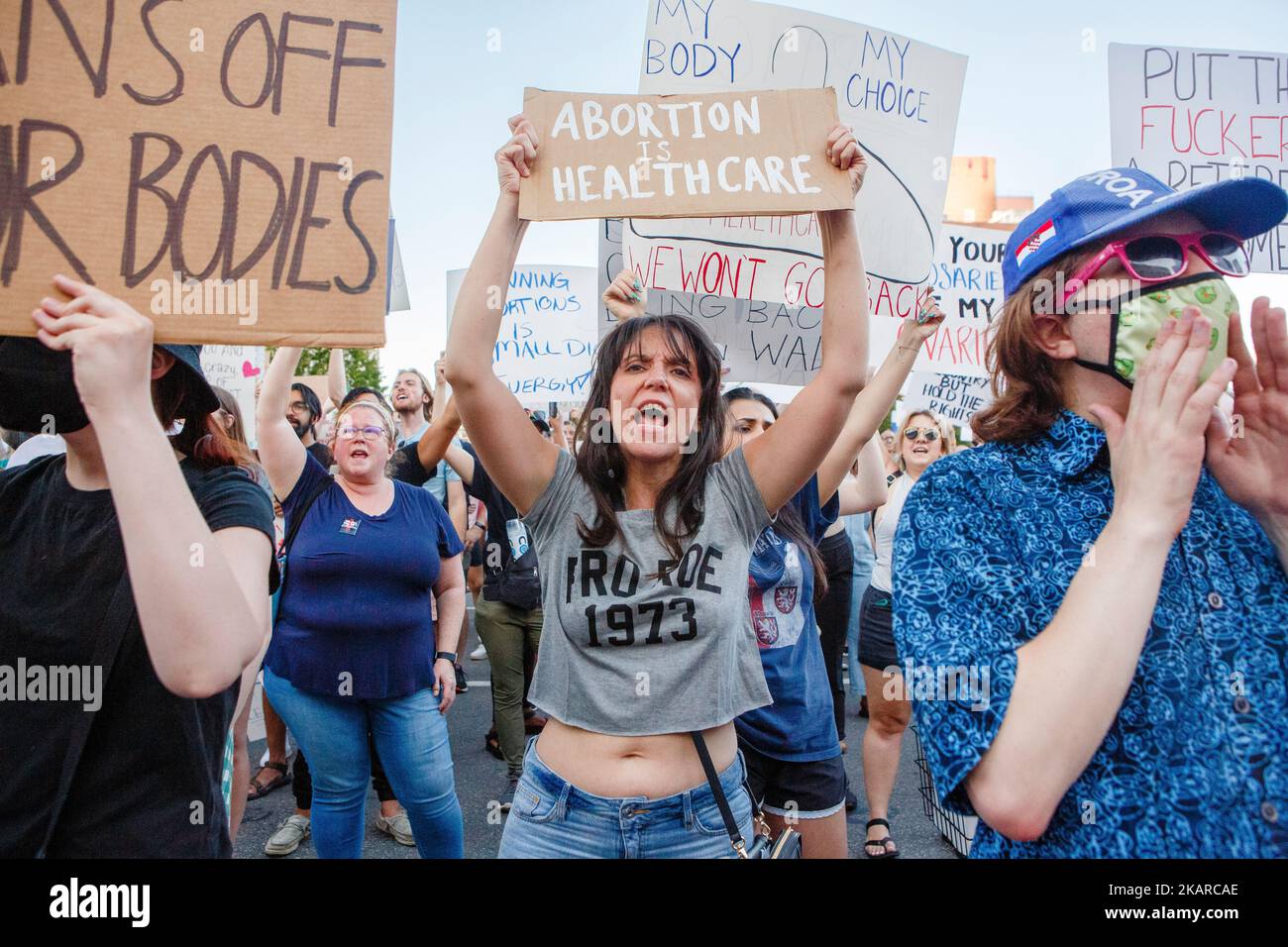 An angry woman stands in crowd holding pro-choice sign at rally Stock Photo