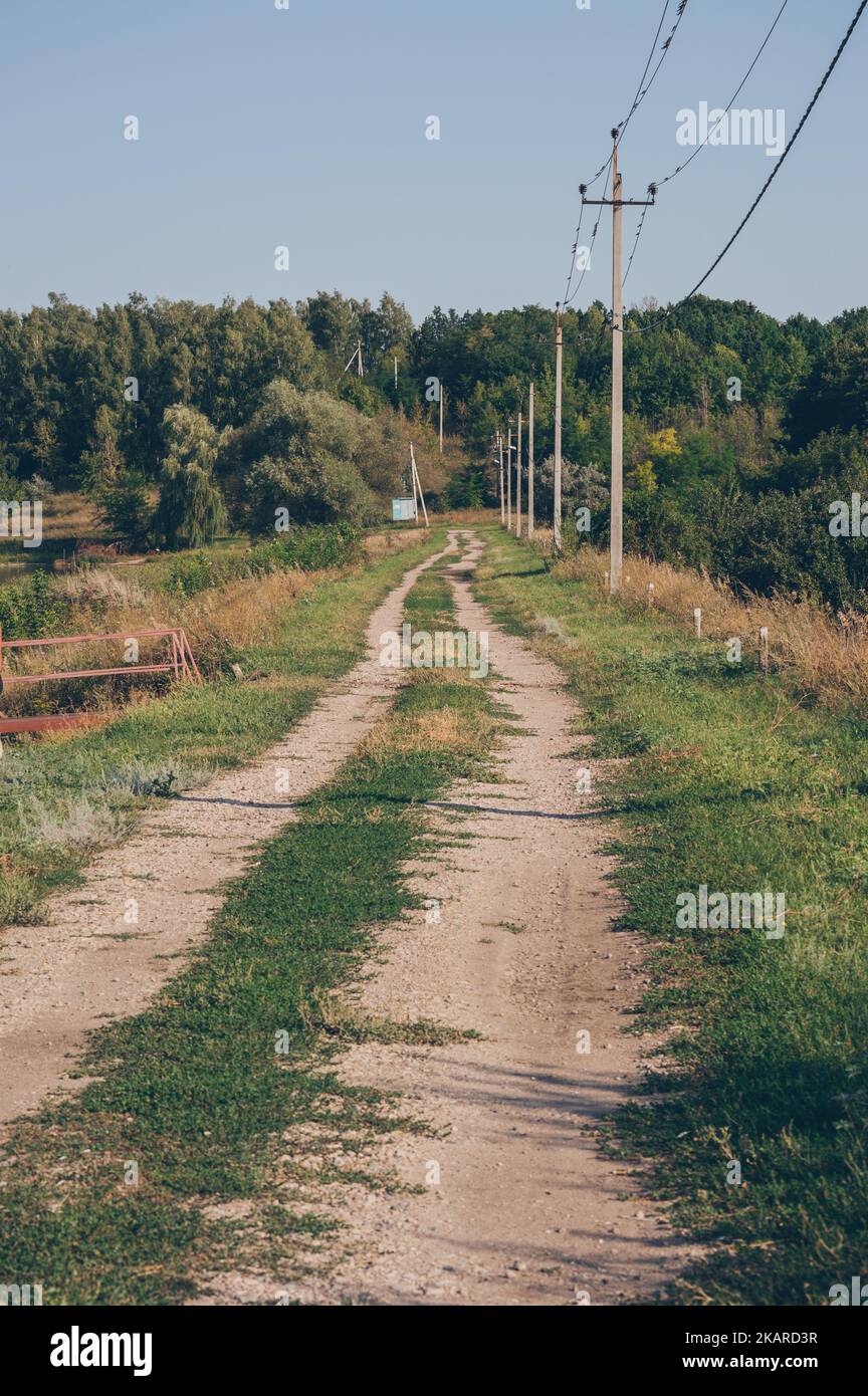 Row of electric poles with wires and country road go afield Stock Photo ...
