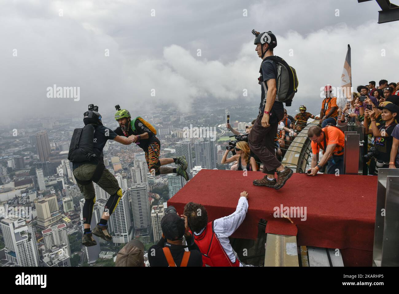 Base jumpers leaps from the 300 meter high open deck at Kuala Lumpur