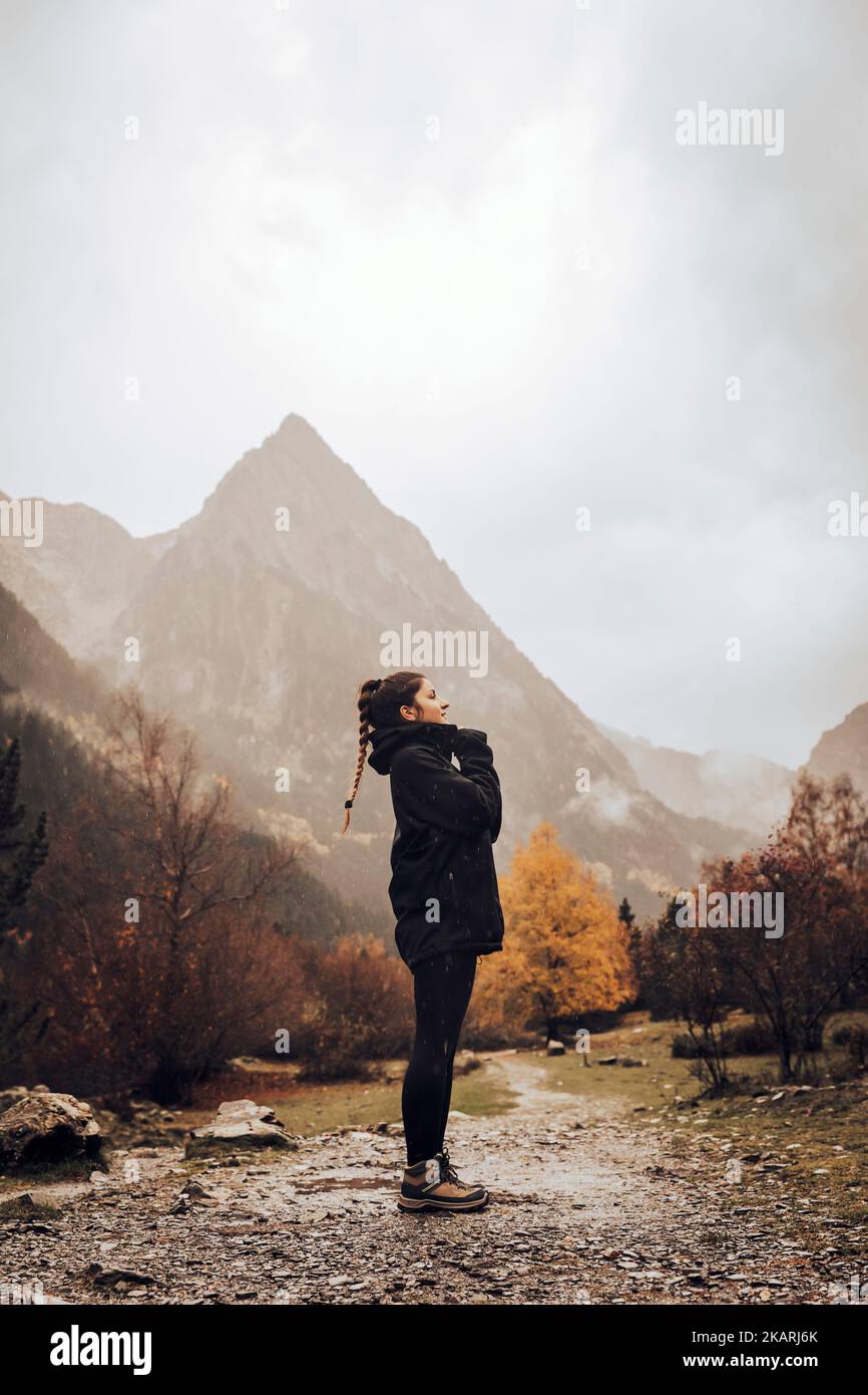 Girl in a path on a mountain route during a cloudy autumn day Stock Photo