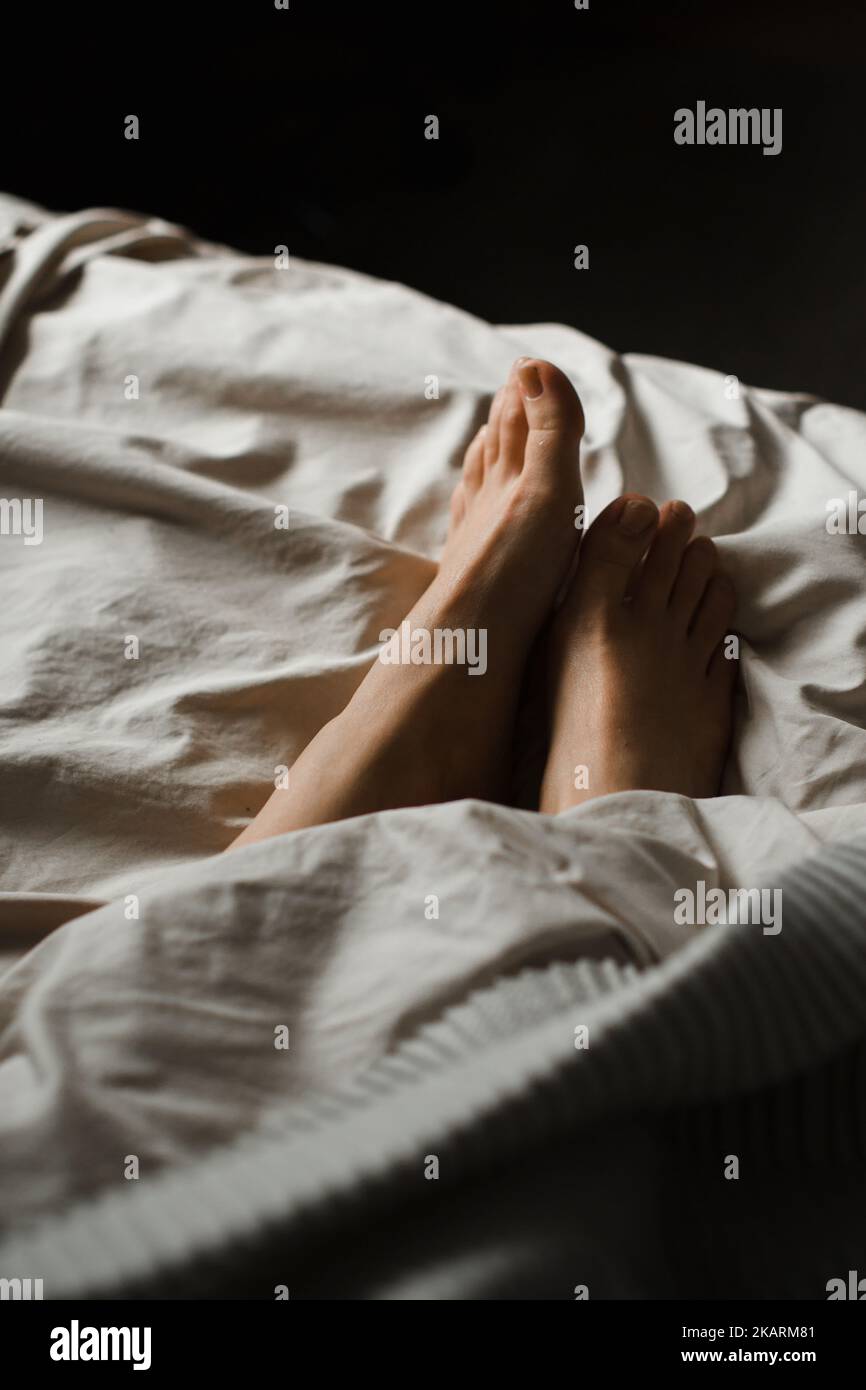 Girl's legs under the blanket Stock Photo