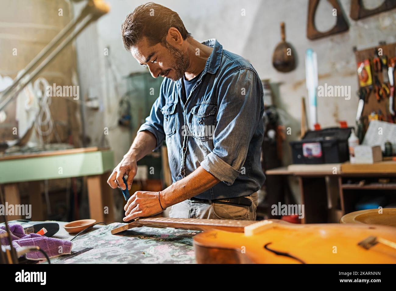 A luthier adjusts the truss rod of a semiacoustic guitar in his