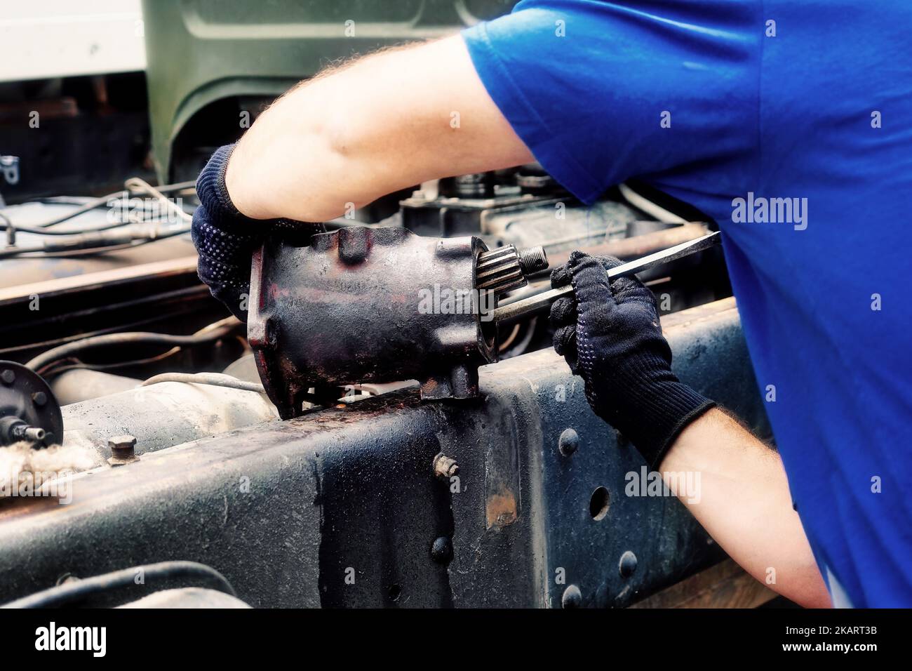 Mechanic disassembles and repairs truck. Closeup rear view