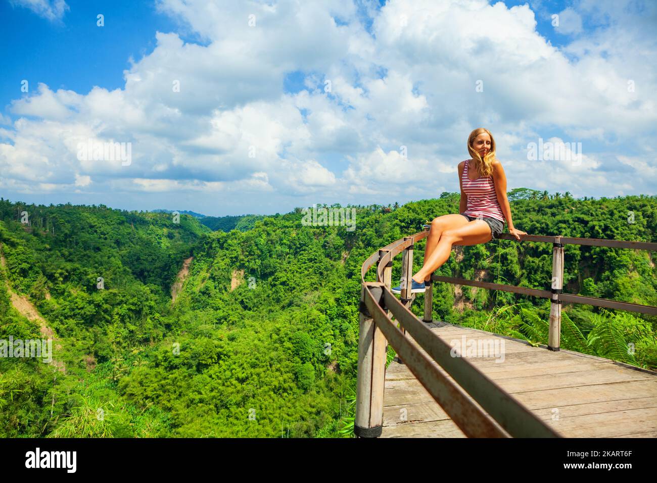 Family vacation lifestyle. Young woman sit on edge of overhanging