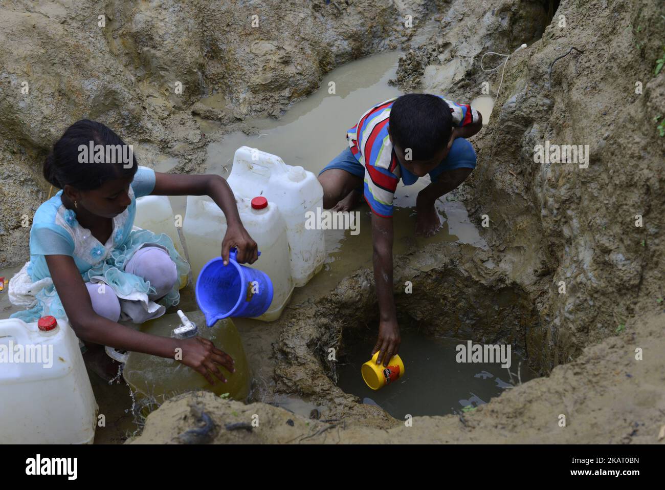 Rohingya children are collects drinking water from the Mud hole at the ...