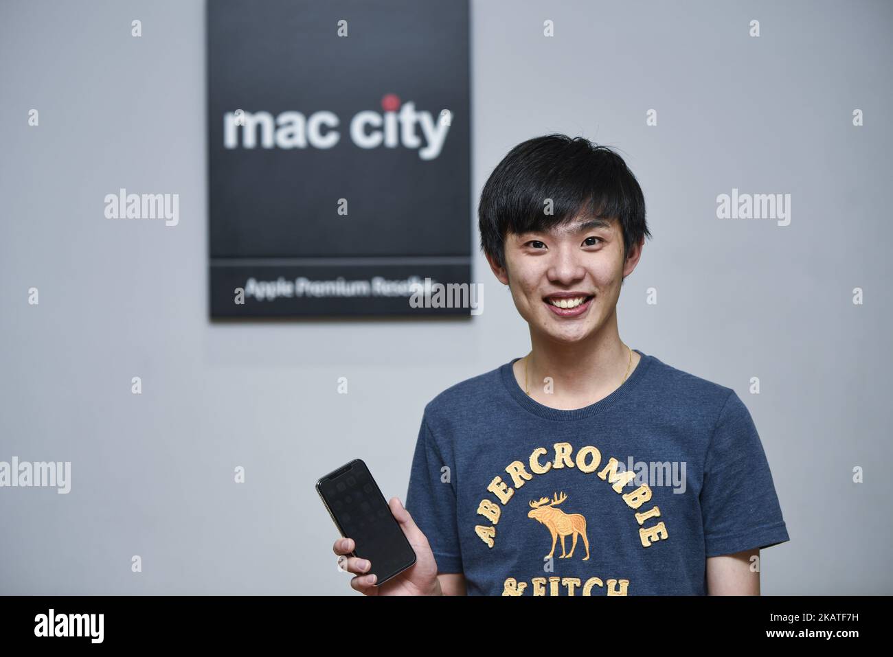 Malaysia's first the iPhone X buyer Zhe Yong(22) poses for a picture with his the newly-released iPhone X at Mac City Apple Reseller Store on November 24, 2017 in Kuala Lumpur, Malaysia. Zhe Yong arrived at the store at 4 p.m. and was leaving the store with his new phone at 12:30 a.m.. (Photo by Chris Jung/NurPhoto) Stock Photo