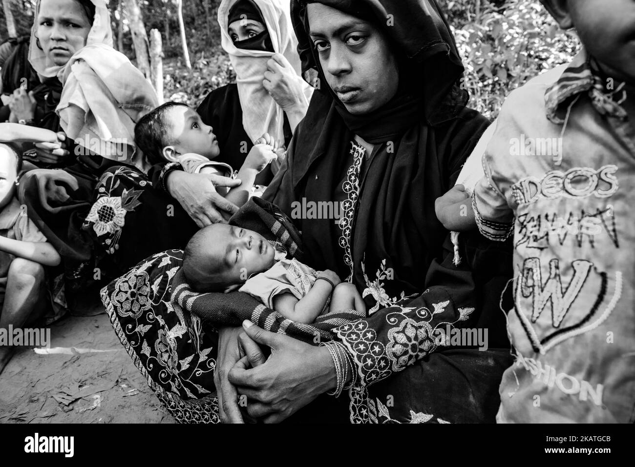 The Rohingya refugee woman holds her young child and waiting for medical help in a field clinic by the non-governmental organization Mercy Malaysia at the Thankhali refugee Camp near Cox's Bazar, Bangladesh, November 25, 2017. (Photo by Szymon Barylski/NurPhoto) Stock Photo