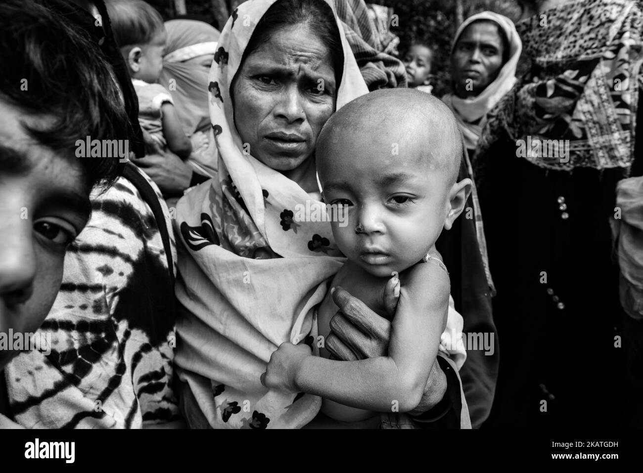 The Rohingya refugee woman holds her young child and waiting for