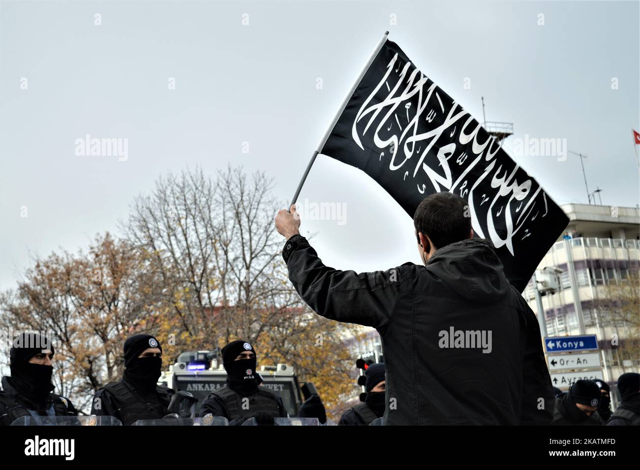 A photo taken in Ankara, Turkey on December 7, 2017 shows a protester waving a black flag with Arabic letters in front of Turkish riot policemen as Turkish Muslims take part in a protest near the U.S. Embassy against its president Donald Trump's officially recognition the city of Jerusalem as the capital of Israel on December 6. (Photo by Altan Gocher/NurPhoto) Stock Photo