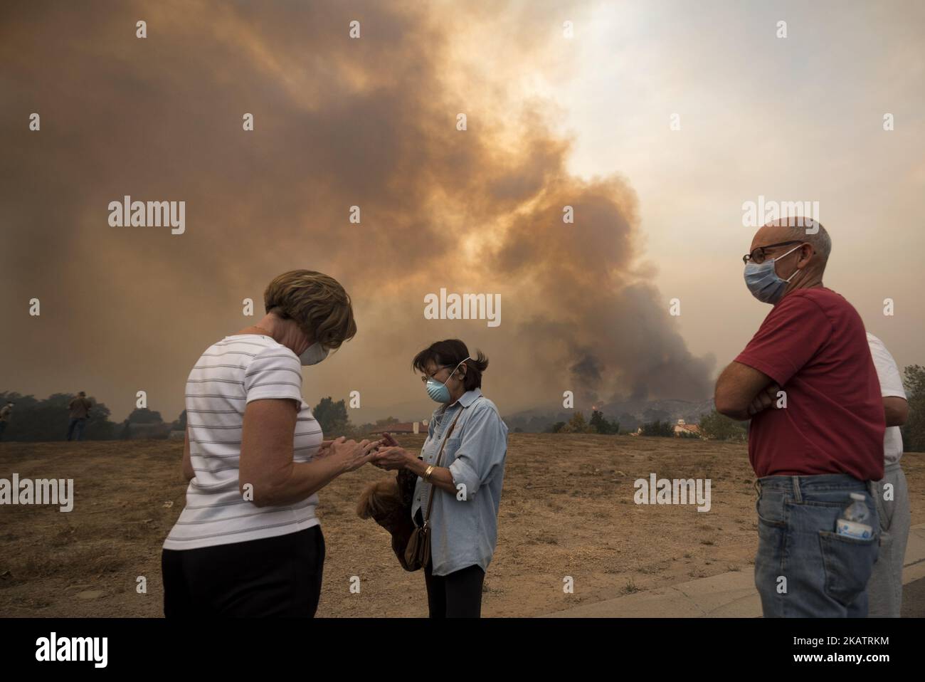 Residents look on as the Thomas wildfire burns in Ojai, California on December 9, 2017. The wind