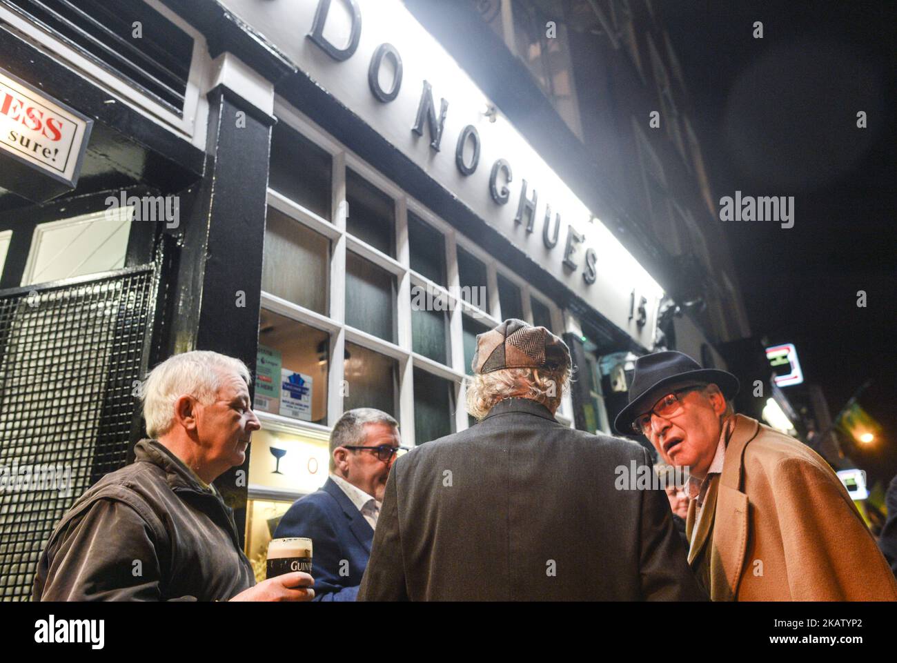 People enjoy a drink and chat outside O'Donoghues pub in Dublin city center just days ahead of Christmas. The 12 Pubs of Christmas has become an annual tradition in Ireland with groups of friends going on drinking routes all over the country. On Thursday, 21 December 2017, in Dublin, Ireland. (Photo by Artur Widak/NurPhoto)  Stock Photo