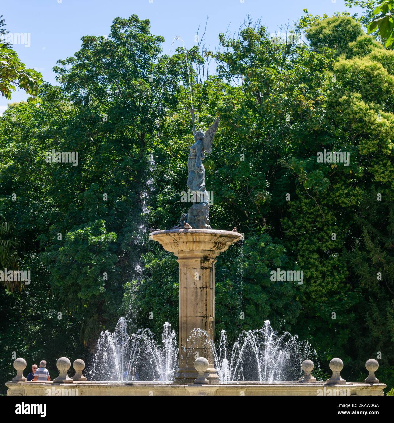 An angel blowing a trumpet figure in a water fountain in a park Stock Photo