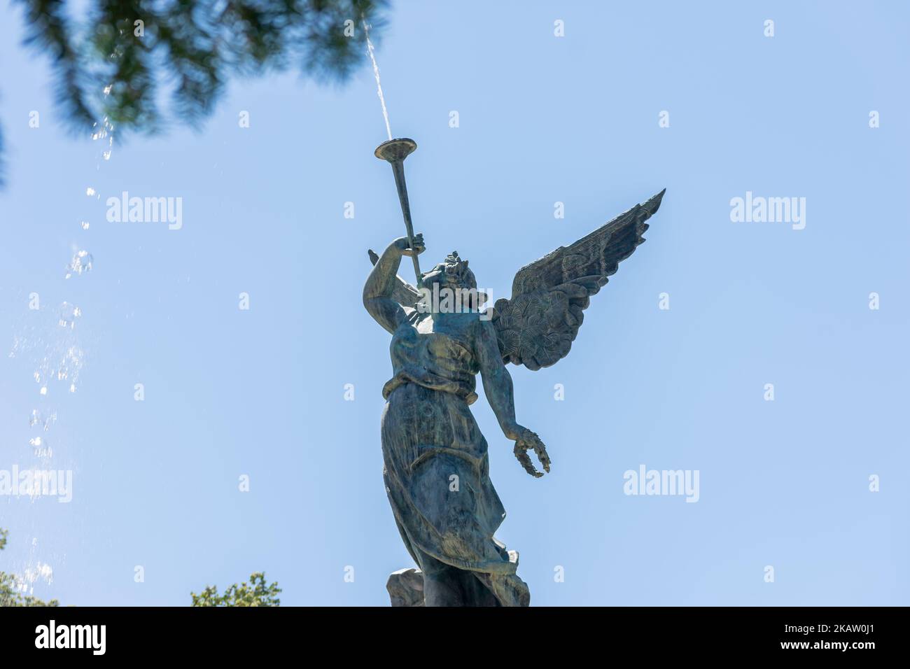 An angel blowing a trumpet figure in a water fountain in a park Stock Photo