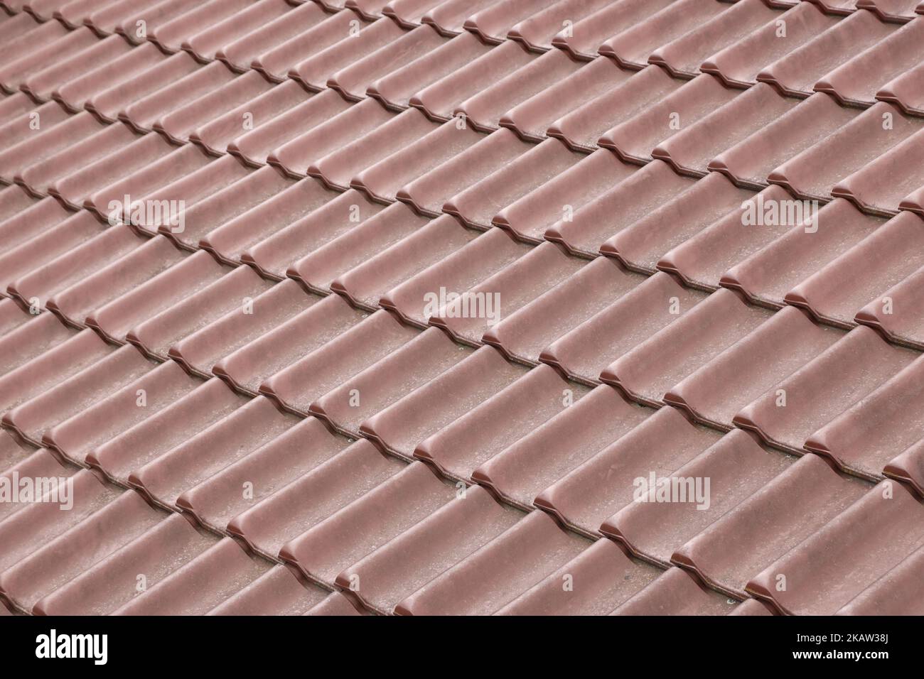 Architectural textured background of brown roof metal tile. Roof of a house with modern metal roof tiles Stock Photo