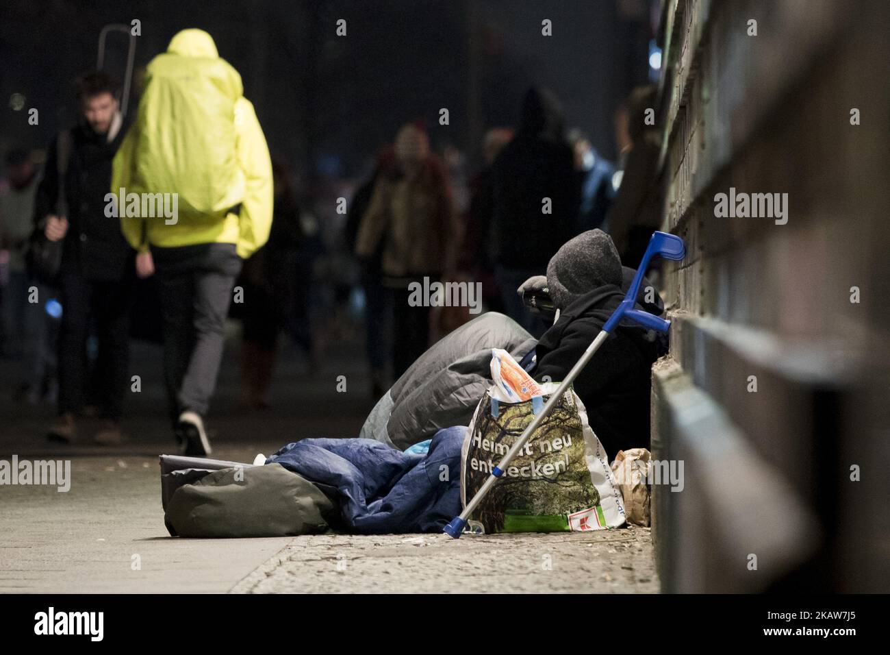 People walk past a homeless person in the Frankfurter Allee in Berlin, Germany on January 19, 2018. (Photo by Emmanuele Contini/NurPhoto) Stock Photo