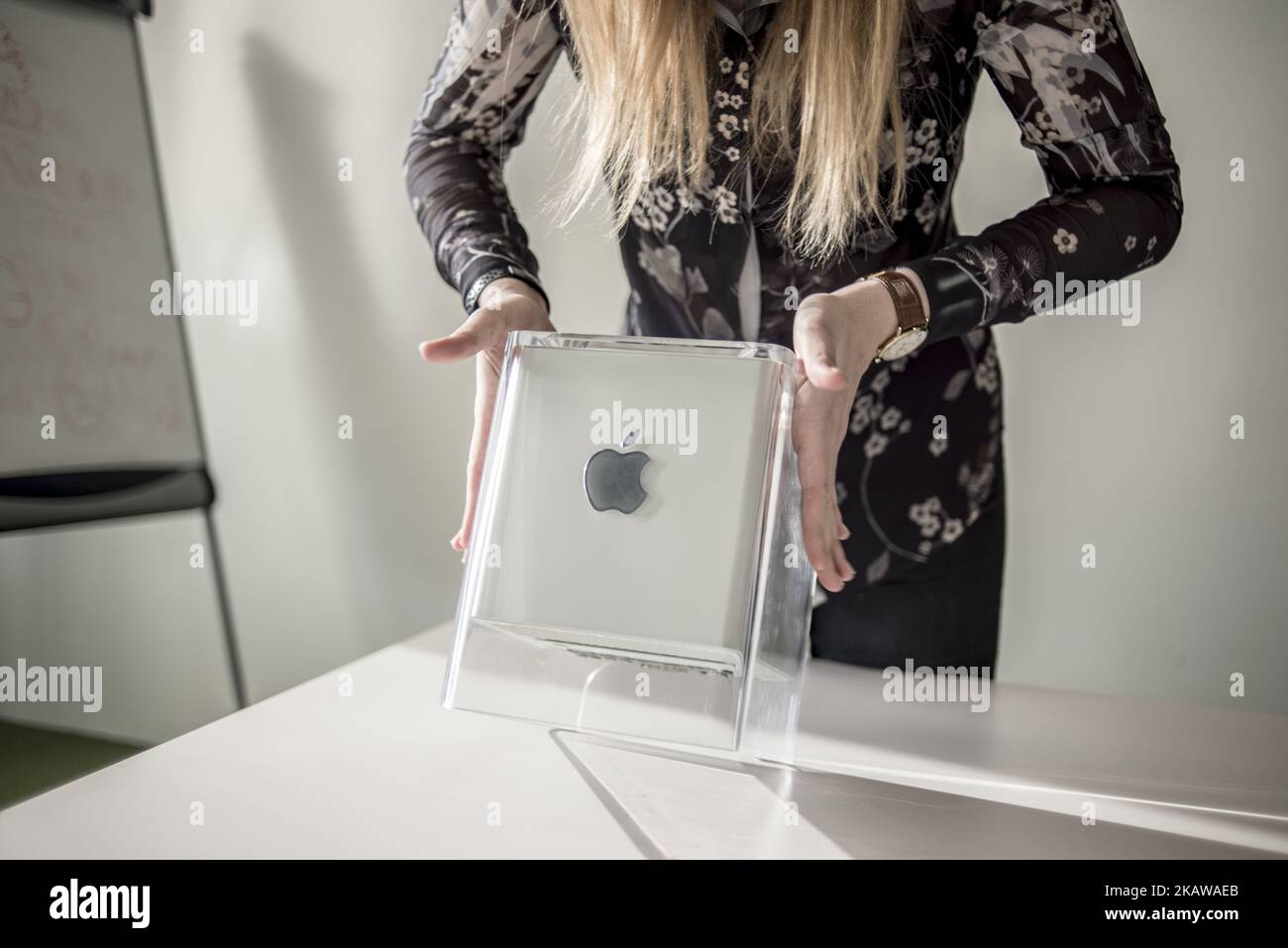 A member of staff shows Power Mac G4 Cube, release date July 2000, at MacPaw's Ukrainian Apple Museum in Kiev, Ukraine on January 26, 2017. Ukrainian developer MacPaw has opened Apple hardware museum at the company’s office in Kiev. The collection has more than 70 original Macintosh models dated from 1981 to 2017. (Photo by Oleksandr Rupeta/NurPhoto) Stock Photo