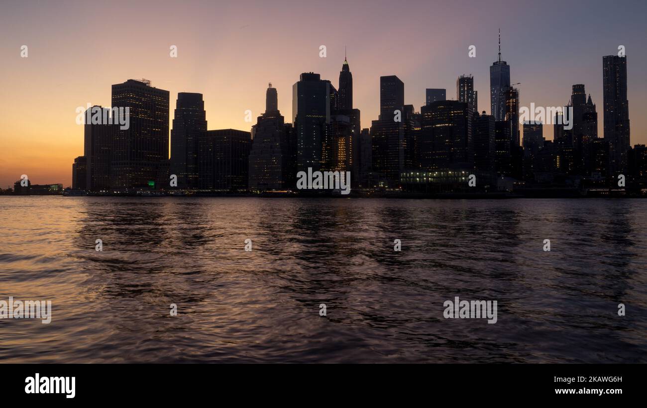 A beautiful scene of New York city with high skyscrapers at sunset in ...