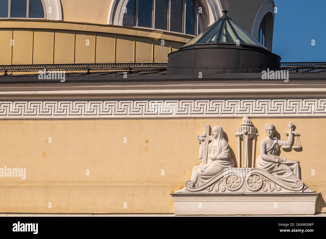Helsinki, Finland - July 19, 2022: Closeup of white sculpted frieze set on yellow facade of National Library featuring Lady Justice and woman with cro Stock Photo