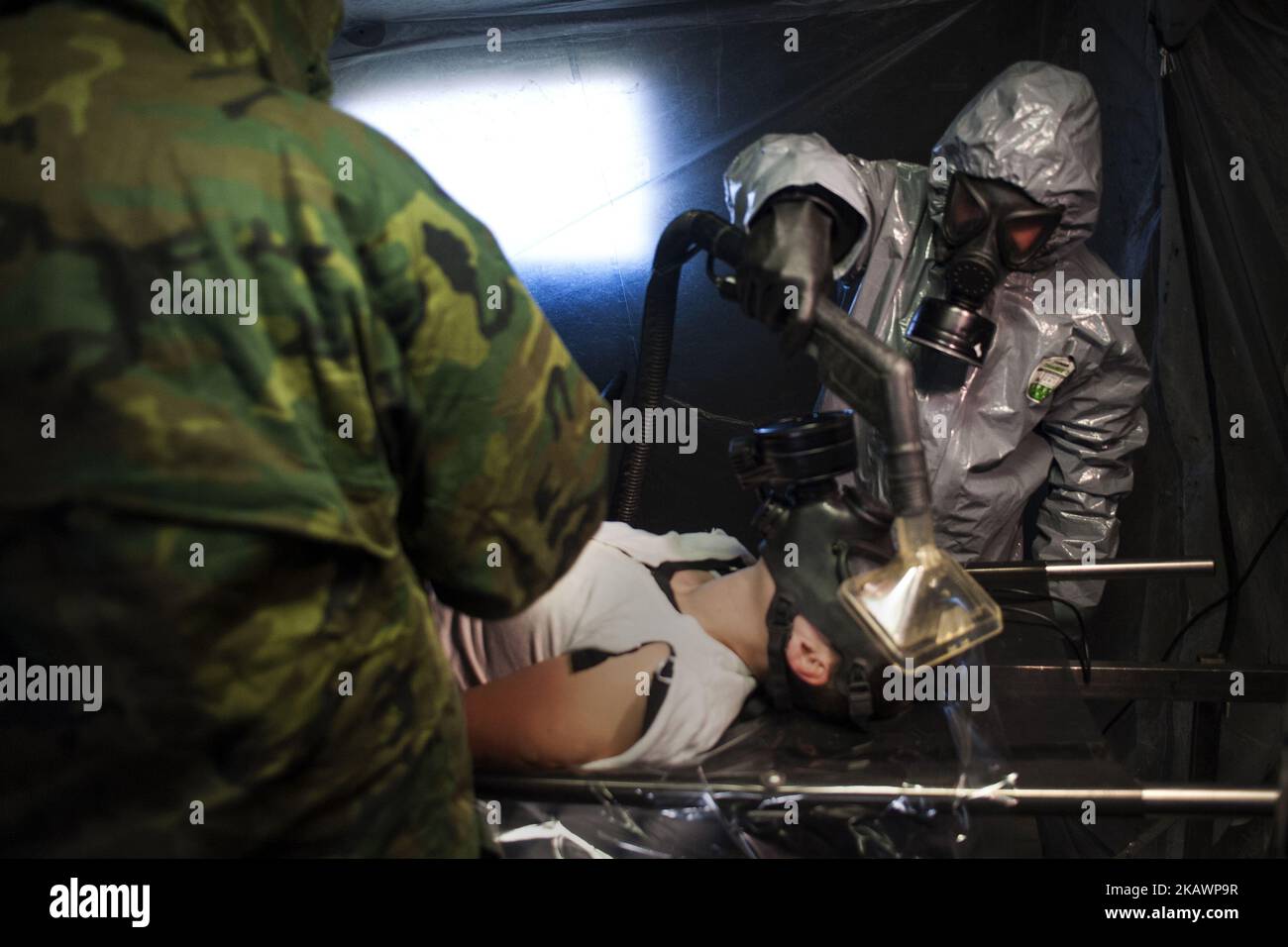 A soldier gives a shower to a victim in the decontamination tunnel in the simulation of a terrorist attack with sarin gas in Santander, Spain on February 23, 2018. (Photo by Joaquin Gomez Sastre/NurPhoto) Stock Photo