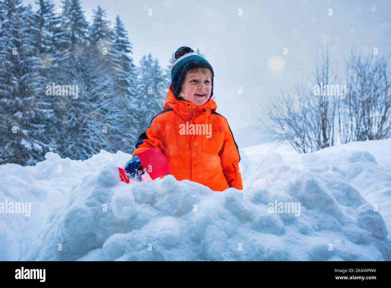 Boy play outside and throw snow with shovel having fun Stock Photo