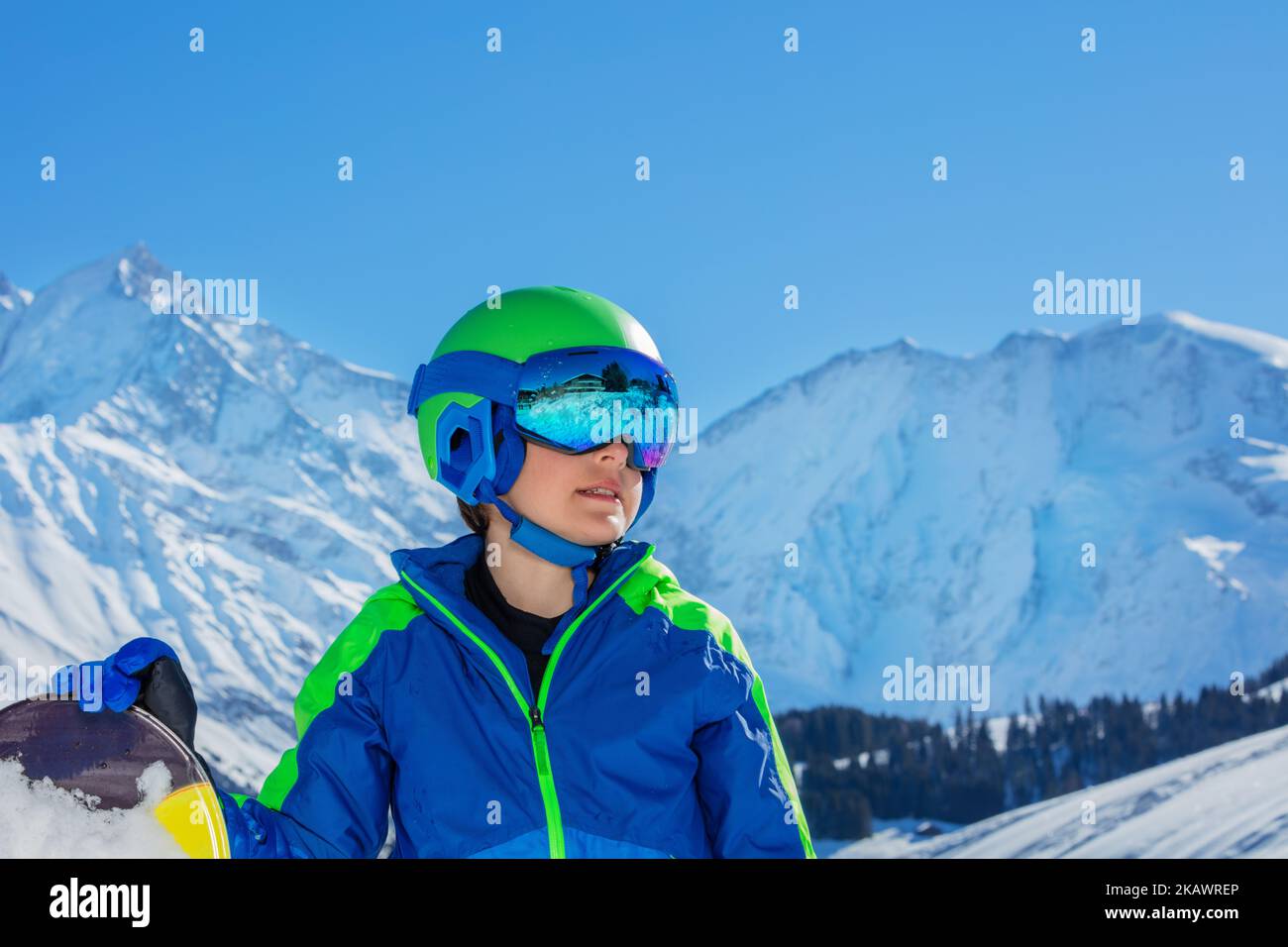 Side view of a boy in ski helmet with sport mask over mountains Stock Photo