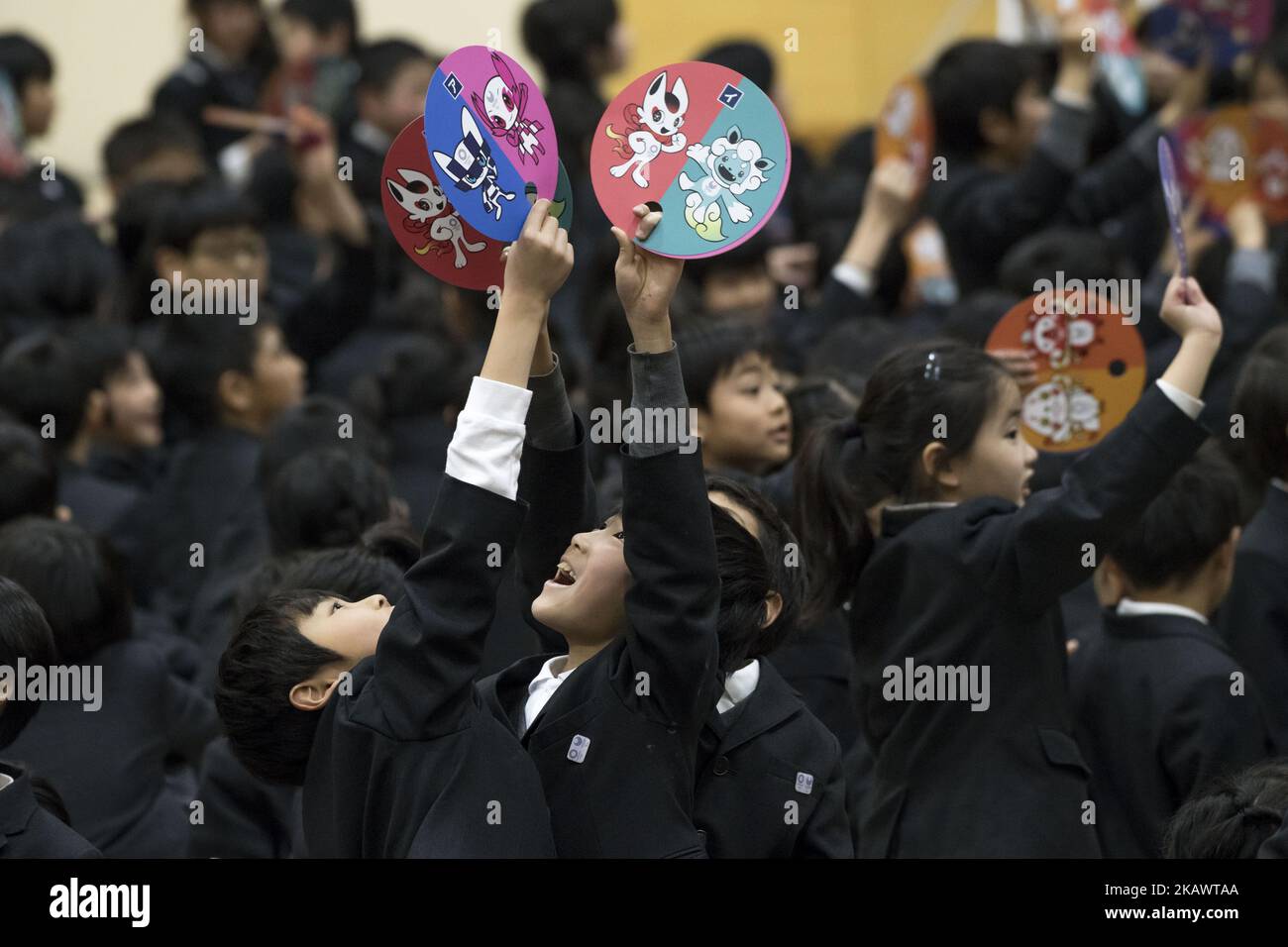 School students celebrate with paper fans showing Tokyo 2020 Olympic Games official mascots at the Hoyonomori Gakuen School in Tokyo, Japan, 28 February 2018. Elementary school students from 16,000 schools accross the country elected the winning mascots from three different designs (Photo by Alessandro Di Ciommo/NurPhoto) Stock Photo