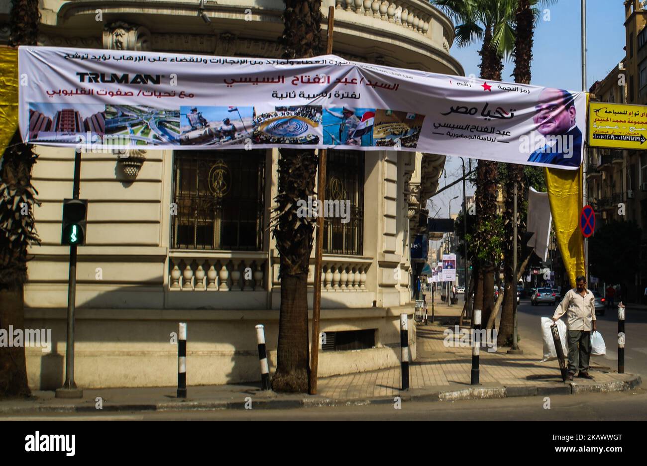 Egyptians walk underneath an election campaign banner erected by supporters of supporters of Ghad Party chairperson Moussa Mostafa Moussa in Cairo, Egypt, 02 March 2018. Egypt will hold its Presidential election between 26 and 28 March 2018. Incumbent President Abdel Fattah al-Sisi is running against Moussa Mostafa Moussa, the head of el-Ghad party. (Photo by Fayed El-Geziry /NurPhoto)  Stock Photo