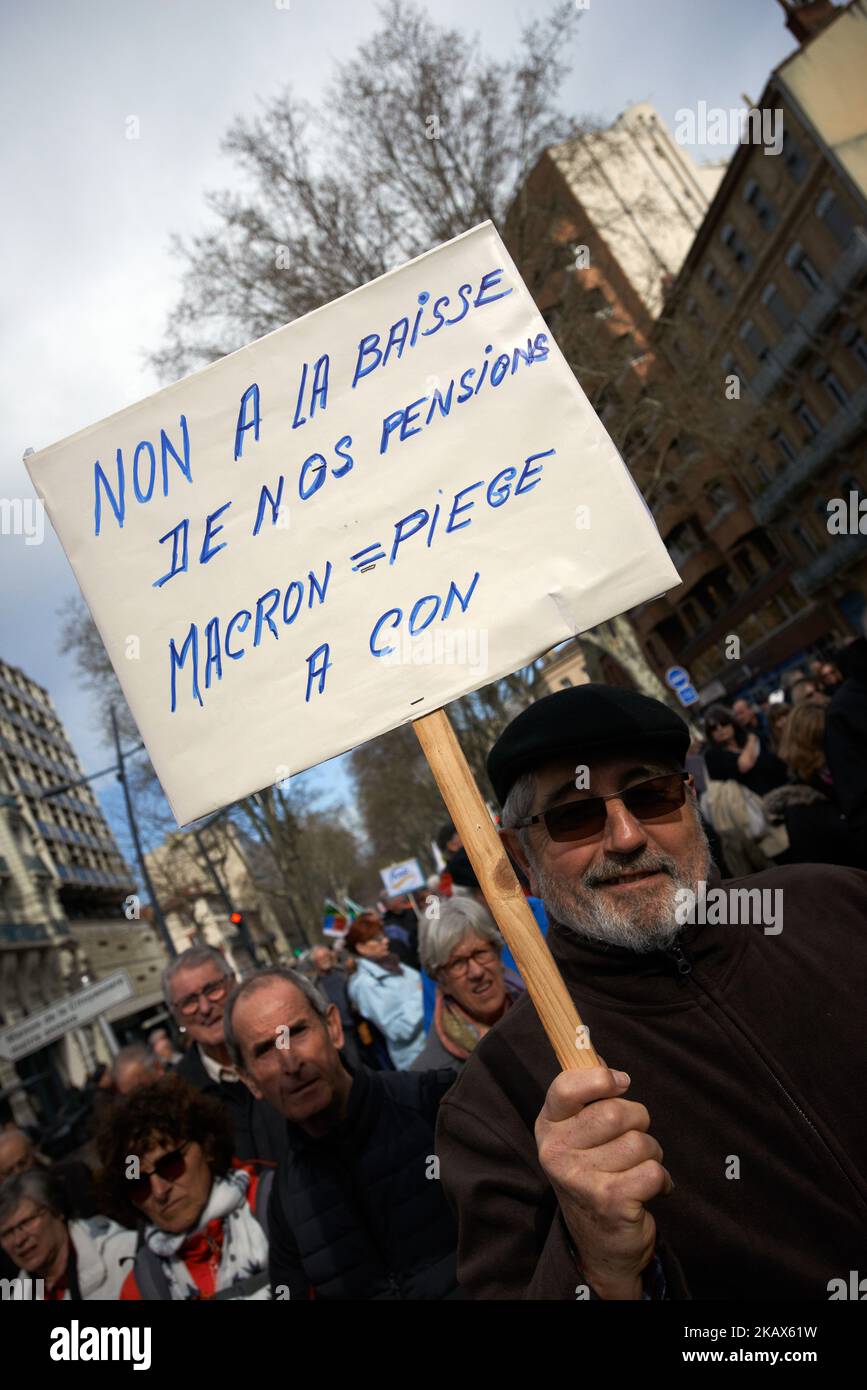 A man holds a placard reading 'No to diminution of pension, Macron = trap for dumbs'.More than 3000 retired people took the streets of toulouse to protest against Macron's politics and discourses on retired people. It's a nation-wide movement of retired workers to protest against a new hike in a tax taken from their pensions. Toulouse. France. March 15th 2018. (Photo by Alain Pitton/NurPhoto) Stock Photo