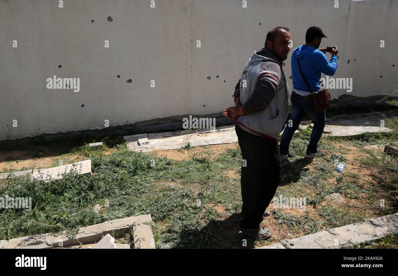 Palestinians check bullet holes in a wall following an exchange of gunfire between Palestinian Hamas security forces and suspects wanted for a bombing that targeted the visiting Palestinian premier's convoy last week in Gaza, in the town of Nuseirat, central Gaza Strip, Thursday, March 22, 2018. (Photo by Majdi Fathi/NurPhoto) Stock Photo