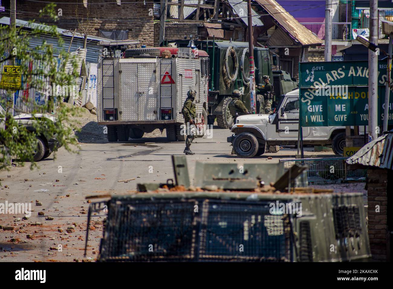 Indian military forces stand alert near the site during a gun battle between Indian armed forces and rebels on April 1, 2018 in Shopain south of Srinagar, the summer capital of Indian administered Kashmir, India. Indian forces shot dead 13 militants in separate gunfights in the Shopian and Anantnag districts of Indian-administered Kashmir, a police officer said. Three Indian military forces and four Kashmiri Muslim civilian were also killed and 50 others were wounded as local residents clashed with Indian forces, the officer said. The news of the militants' killings triggered civilian protests Stock Photo