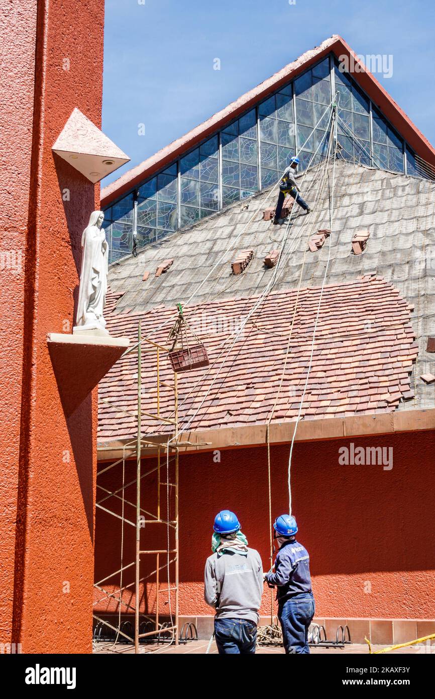 Bogota Colombia,El Chico Carrera 11 Parroquia Immaculada Concepcion church outside exterior,man men male repairing replacing roof tiles ropes pulley p Stock Photo