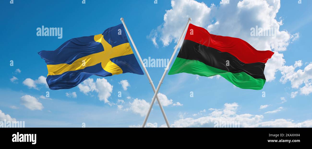 two crossed flags Pan-African and Sweden waving in wind at cloudy sky ...