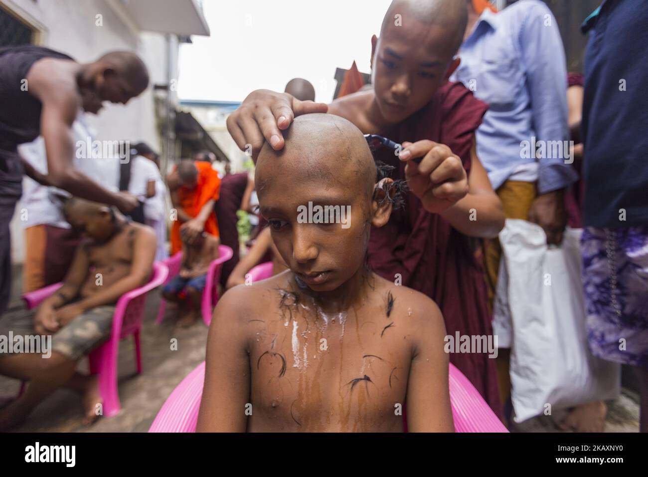 A Buddhist monk shaves the head of a Sri Lankan boy during a ceremony to be ordained as novice Buddhist monks (samanera) in Colombo, Sri Lanka on Sunday 29 April 2018 which also marks the Vesak full moon poya day Celebrated by Buddhists to mark three momentous events in Lord Buddha's life – his birth, enlightenment, and his departure from the human world. (Photo by Tharaka Basnayaka/NurPhoto) Stock Photo