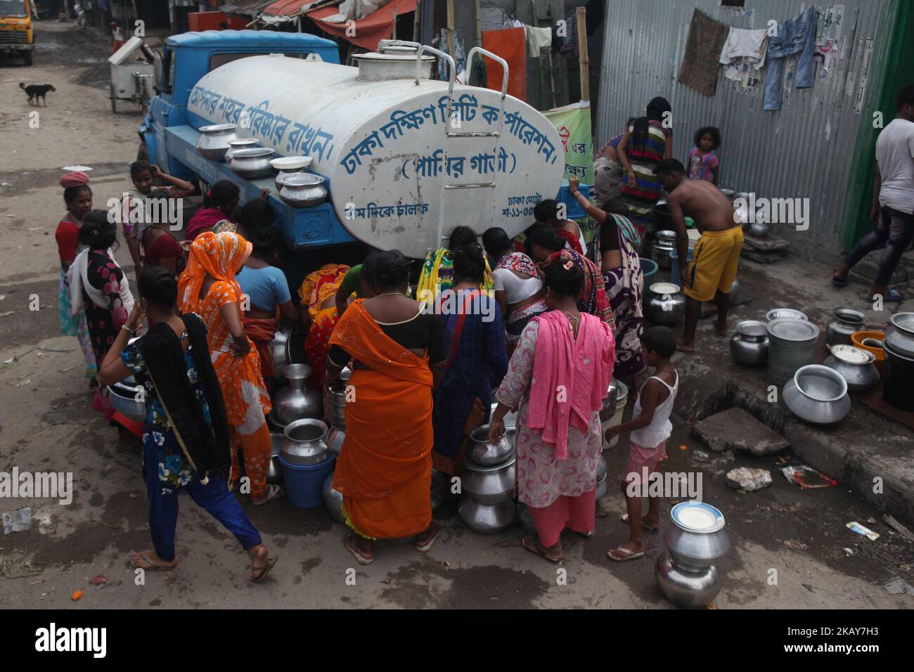 Bangladeshi women collect drinking water in Dhaka on June 5, 2018.With a population of over 15 million people, Dhaka is the capital of Bangladesh is considered a mega-city and shares many of the water management problems common to other major cities.While efforts are made to sustain water quantity and quality in city water supplies, Dhaka pumping has caused groundwater levels to drop more than 200 feet over the last 50 years and these levels continue to decline at a rate of up to 9 feet per year. (Photo by Mehedi Hasan/NurPhoto) Stock Photo
