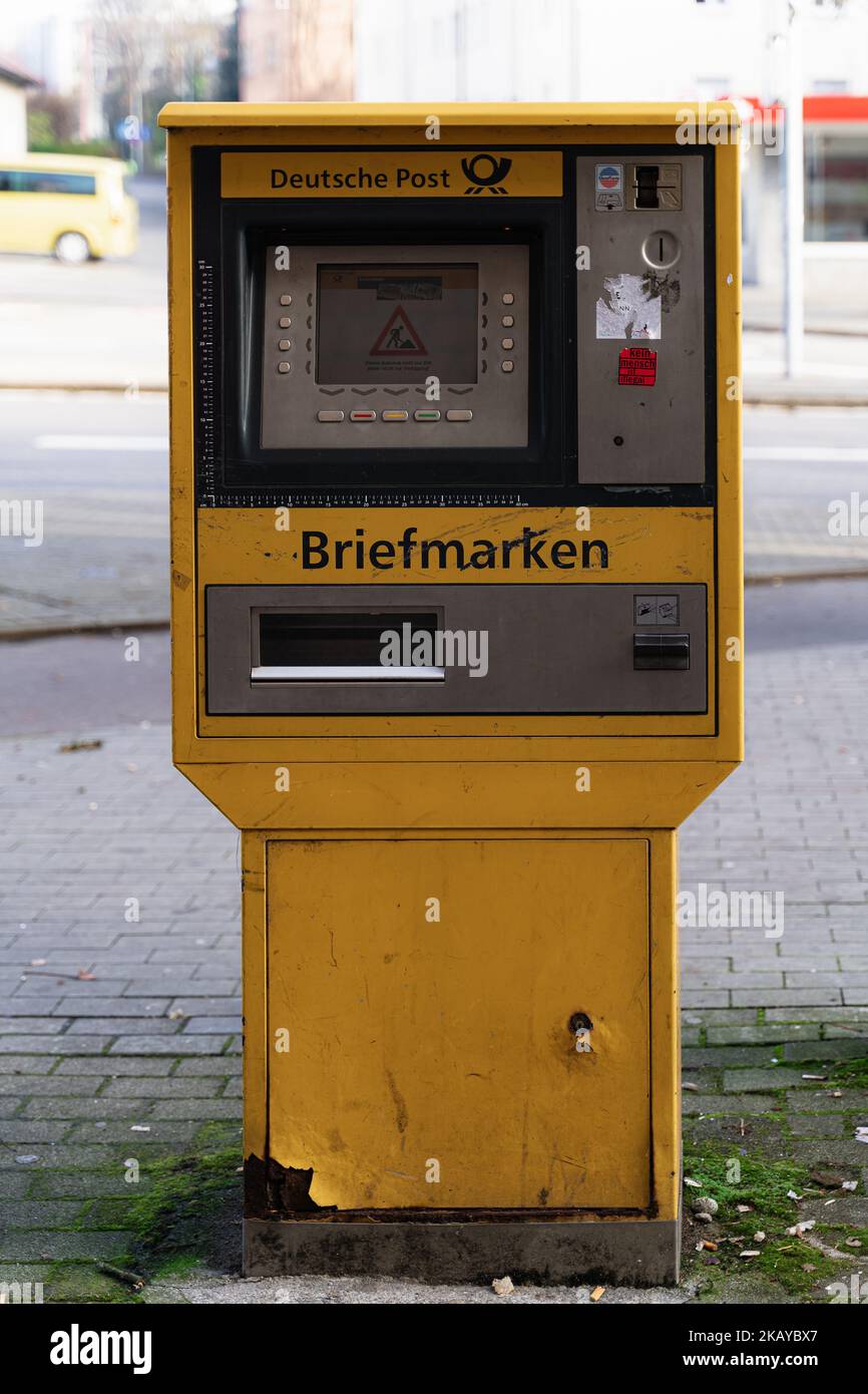 A vertical shot of a german post stamp machine with heavy signs of use