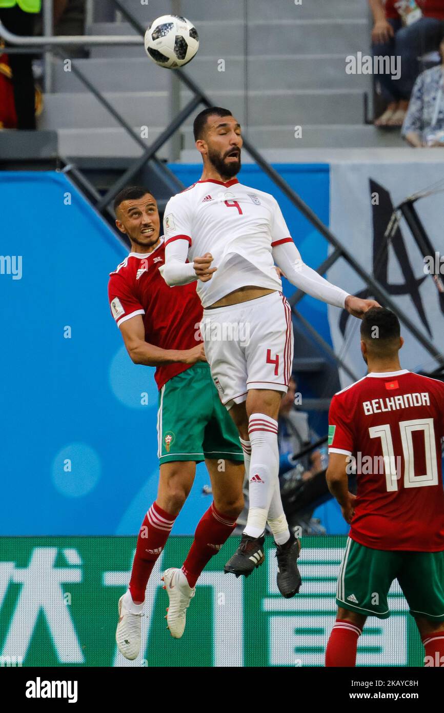 Romain Saiss (L) of Morocco national team and Roozbeh Cheshmi of IR Iran national team vie for a header during the 2018 FIFA World Cup Russia Group B match between Morocco and IR Iran on June 15, 2018 at Saint Petersburg Stadium in Saint Petersburg, Russia. (Photo by Mike Kireev/NurPhoto) Stock Photo