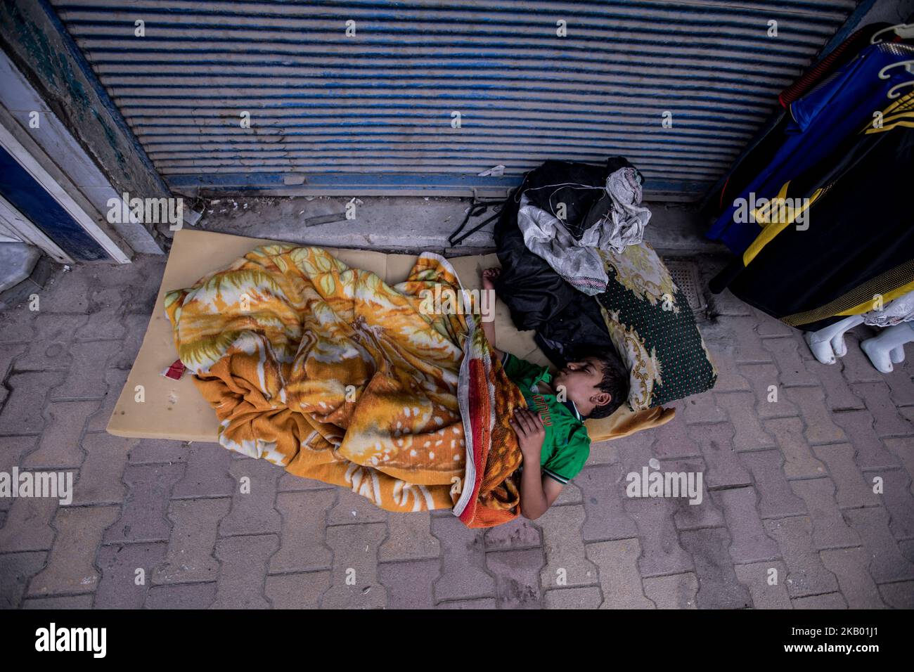 A homeless boy at his sleeping place on a street in Qamishli / Syria (Photo by Sebastian Backhaus/NurPhoto) Stock Photo