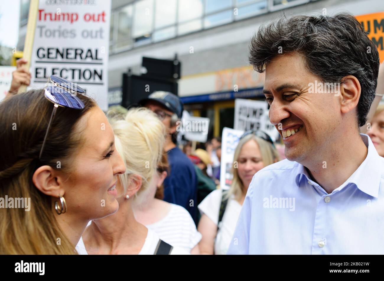 Former leader of the Labour Party Ed Miliband (right) gives an interview as demonstrators opposing the UK visit of US President Donald Trump protest in London, England, on July 13, 2018. President Trump arrived on British soil yesterday on his first visit to the UK since taking office. Protests have been planned across the country – today in London in particular, although Mr Trump is spending the day outside the city. (Photo by David Cliff/NurPhoto) Stock Photo