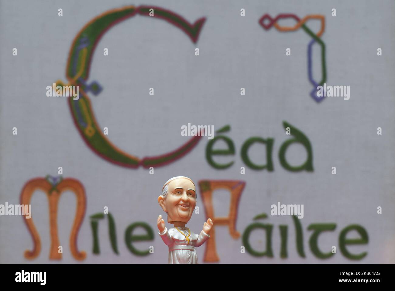 A mini size Pope Francis Bobble head in front of a 'Cead Míle Failte' ('a hundred thousand welcomes' Irish saying) on display at Dublin's Balla Ban Art Gallery. The gallery owner Frank O'Dea will be giving them out for free with every purchase made during the Pope's visit to Ireland. Pope Francis is due to visit Ireland from August 21 to 26 in what will be the first papal visit since Pope John Paul II came in 1979. On Wednesday, July 18 2018, in Dublin, Ireland. (Photo by Artur Widak/NurPhoto)  Stock Photo