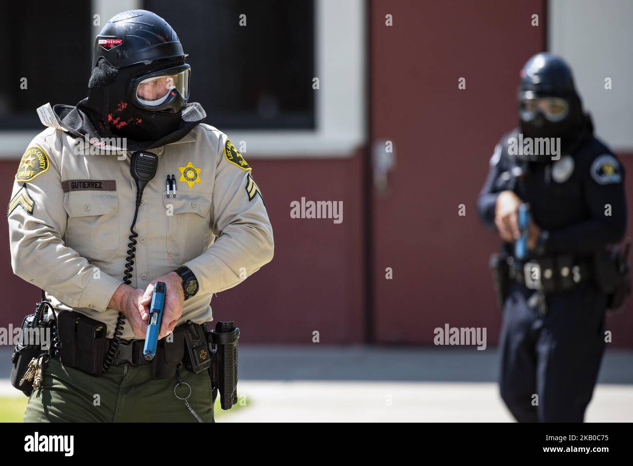 A Los Angeles Sherif's deputy and a police officer participate in an ...