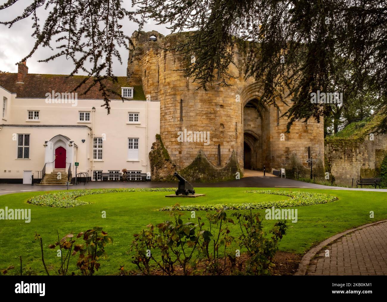 The exterior of Tonbridge Castle gatehouse with a canon in the