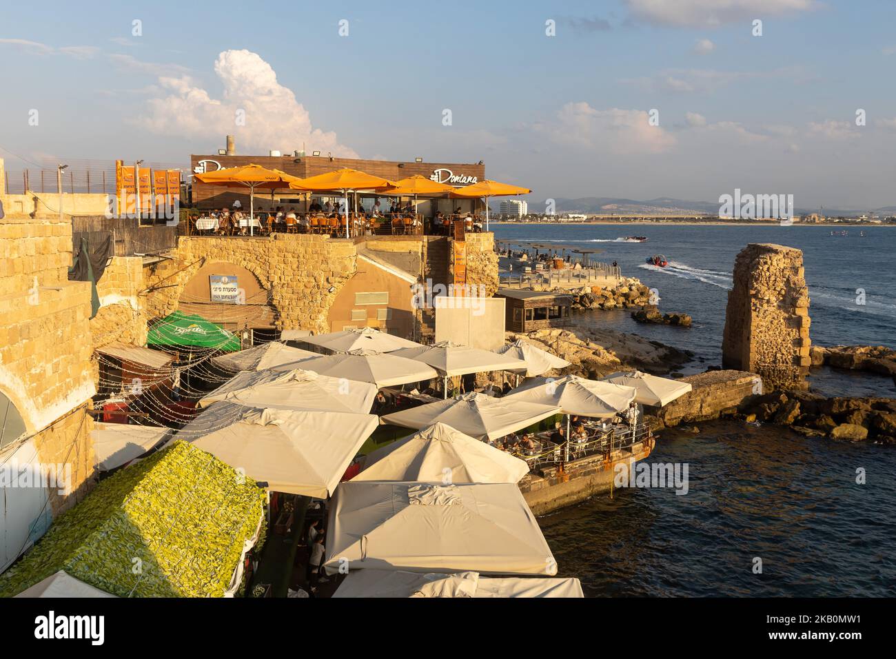 Acre, Israel - November 01, 2022, DONIANA, restaurant, view from the waterfront to the restaurant, tables and the sea. People relax in a cafe overlook Stock Photo