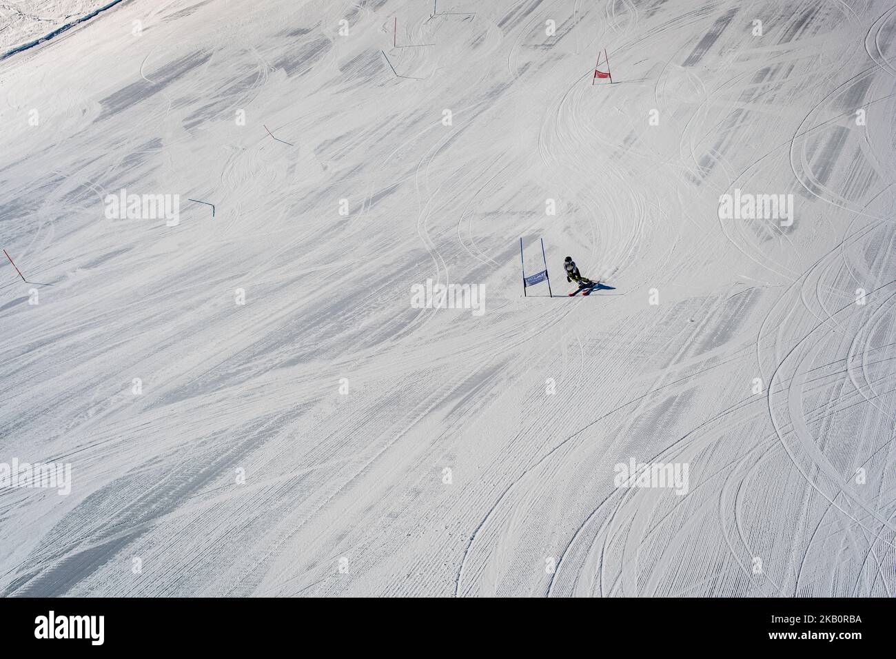 Skier passing ski gates, flag at speed practising on a downhill slope