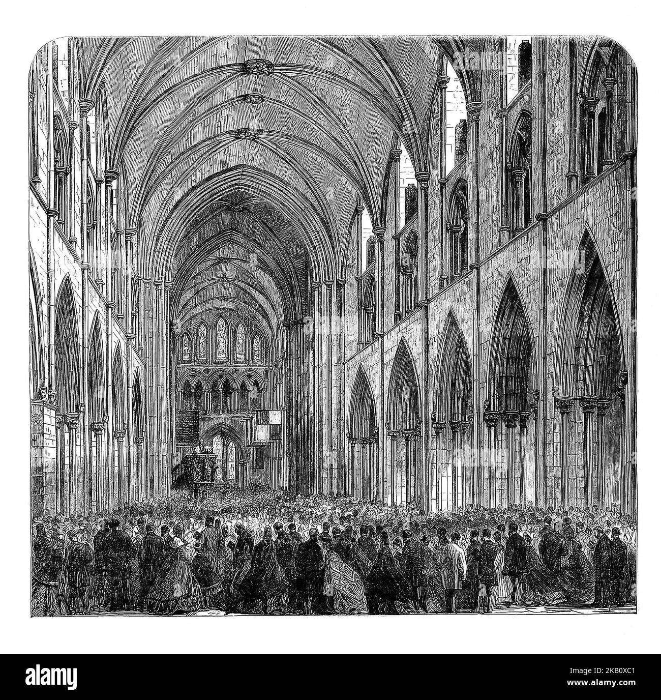 The crowded nave during the opening of the restored St Patrick's Cathedral in Dublin Ireland. In 1805, the north transept was in ruins and the south transept was in a poor condition. Major reconstruction, paid for by Benjamin Guinness, in 1860–65, was inspired by the fear that the cathedral was in imminent danger of collapse, few records of the work survive today. A failure to preserve records means that little is known as to how much of the current building is genuinely mediæval and how much is Victorian pastiche. Stock Photo