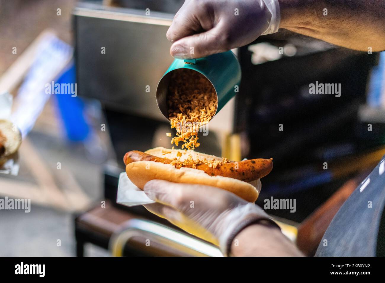 Closeup of chef holding a sausage in a roll, hot dog with lions being