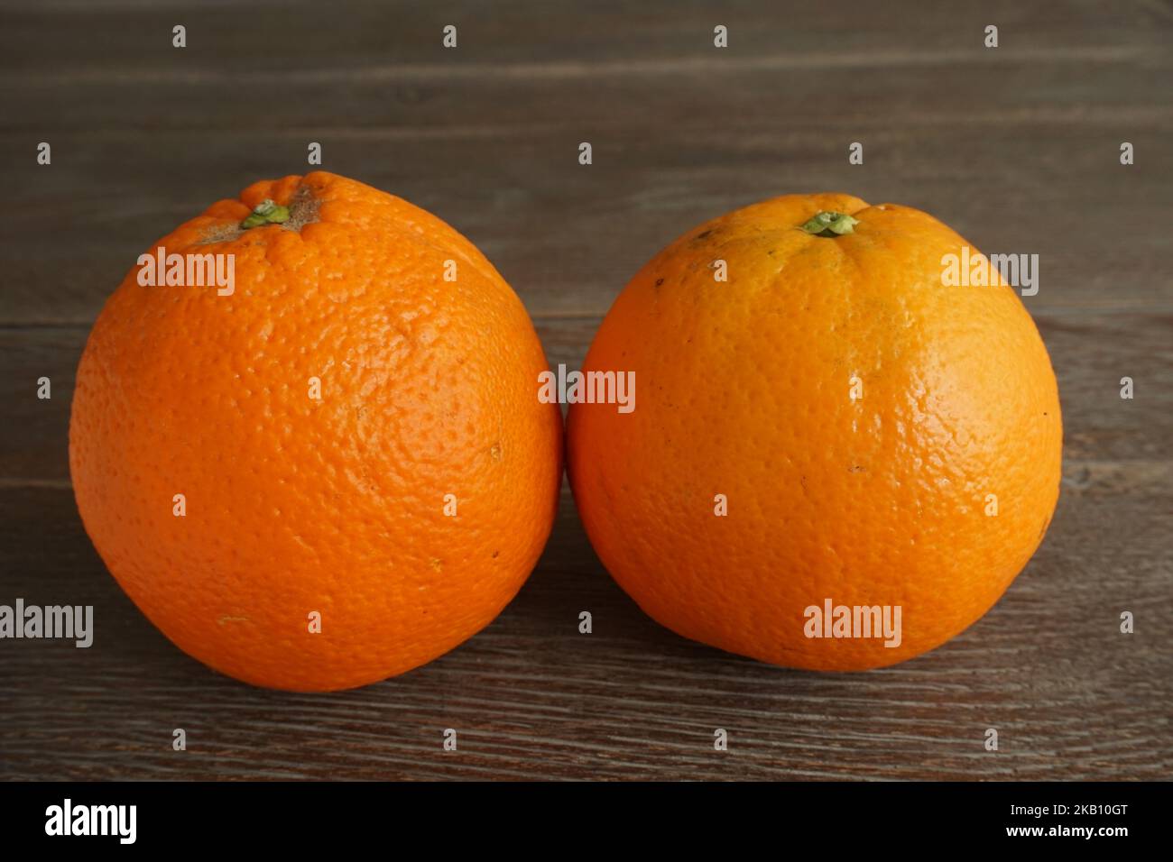 two oranges isolated on wooden table Stock Photo