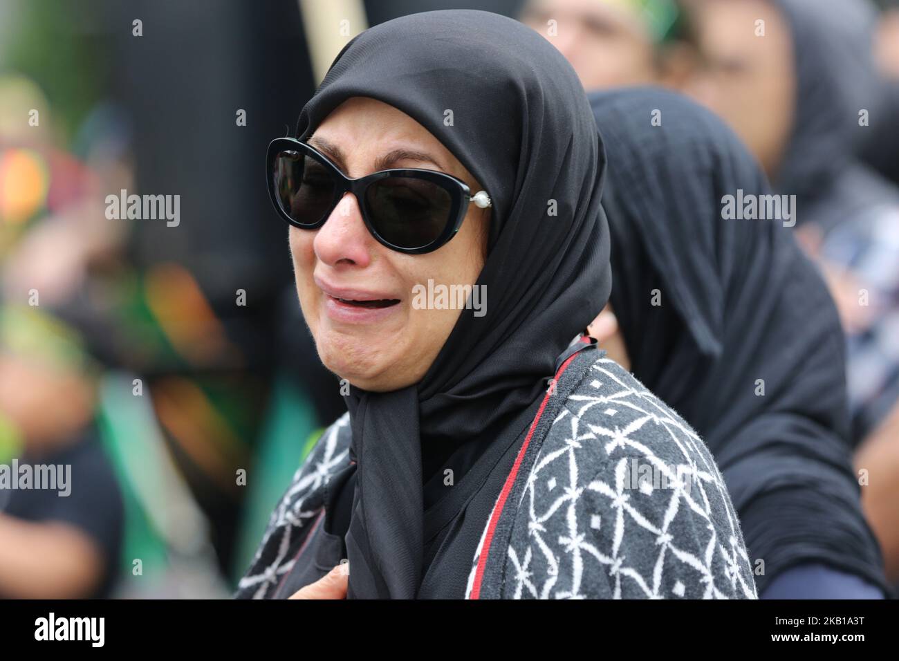 Woman crying as Shiite Muslim mourners take part in a Muharram procession in Toronto, Ontario, Canada, on September 20, 2018. Hundreds of Shiite Muslims took to the streets to commemorate the death of the third Imam, Hussein, slain along with 72 of his comrades in a battle against the army of the seventh-century caliph Yazid. In keeping with the military nature of these Ashura processions, mourners simulate self-flagellation and pound on their chests to the thump of a bass drum and the crackle of a snare. (Photo by Creative Touch Imaging Ltd./NurPhoto) Stock Photo