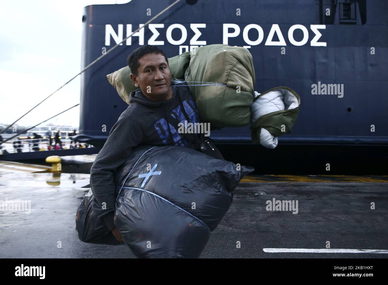 Refugees and migrants disembark from the ferry 'Nissos Rodos,' which arrived from Lesvos Island, at the port of Piraeus, near Athens, Greece, on the morning of September 29, 2018. More than 400 refugees and migrants of different nationalities from the Moria hotspot on Lesvos Island are transferred to the main land in an effort to relieve the overcrowding camp which according the environmental and health inspectors from Lesvos’ public health directorate, is unsuitable and dangerous for public health and the environment. (Photo by Panayotis Tzamaros/NurPhoto) Stock Photo